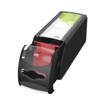 A black Tork Xpressnap Fit® 272901 countertop napkin dispenser from Essity Professional Hygiene Germany GmbH is equipped with a transparent lid that can be partially opened to present red napkins inside. Its sleek and compact design includes a label with green accents and offers single sheet dispensing for efficient use.
