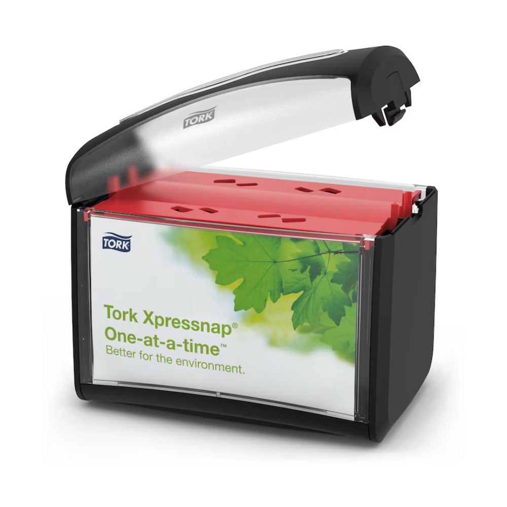 A black and transparent Tork Xpressnap® 272611 table napkin dispenser with a transparent lid presents red napkins inside. The label reads "Tork Xpressnap, individually – better for the environment" and features an image with green leaves, indicating both hygiene and reduced napkin consumption.