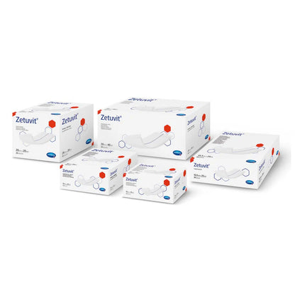 Five medical boxes of the Hartmann Zetuvit absorbent compress brand in various sizes, neatly stacked, with blue-white packaging with red accents and the image of a bandage on each box.