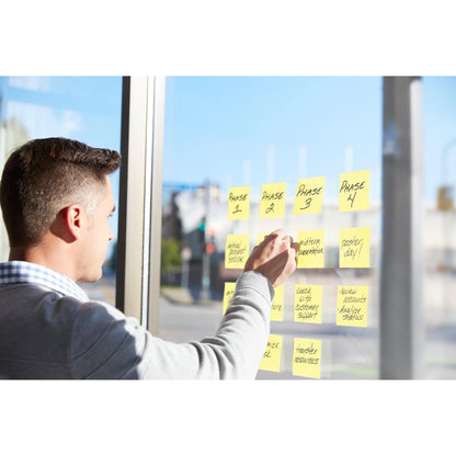 Eine Person ordnet handschriftlich Projektphasen wie "Phase 1" und "Zwischenpräsentation" auf einem Fenster mit den Post-it® Super Sticky Z-Notes, Gelb (76x127mm, 90 Blatt/Block), PEFC-zertifiziert in Kartonverpackung der 3M Deutschland GmbH.