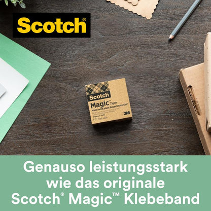 A box of Scotch® Magic™ Tape (19 mm x 30 m, 1 roll, with 66% plant-based adhesive from 3M Deutschland GmbH) lies on a wooden table next to green-white paper, a pen, and a note card. "Just as powerful as the original invisible tape.