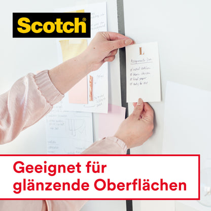Jemand benutzt Scotch® Crystal Klebeband, 19mm x 25 m + 5m GRATIS auf einem Handabroller (3M Deutschland GmbH), um eine Notiz auf einem Whiteboard mit anderen Papieren zu befestigen. Auf der Tafel steht "Geeignet für glänzende Oberflächen" und zeigt das Logo.