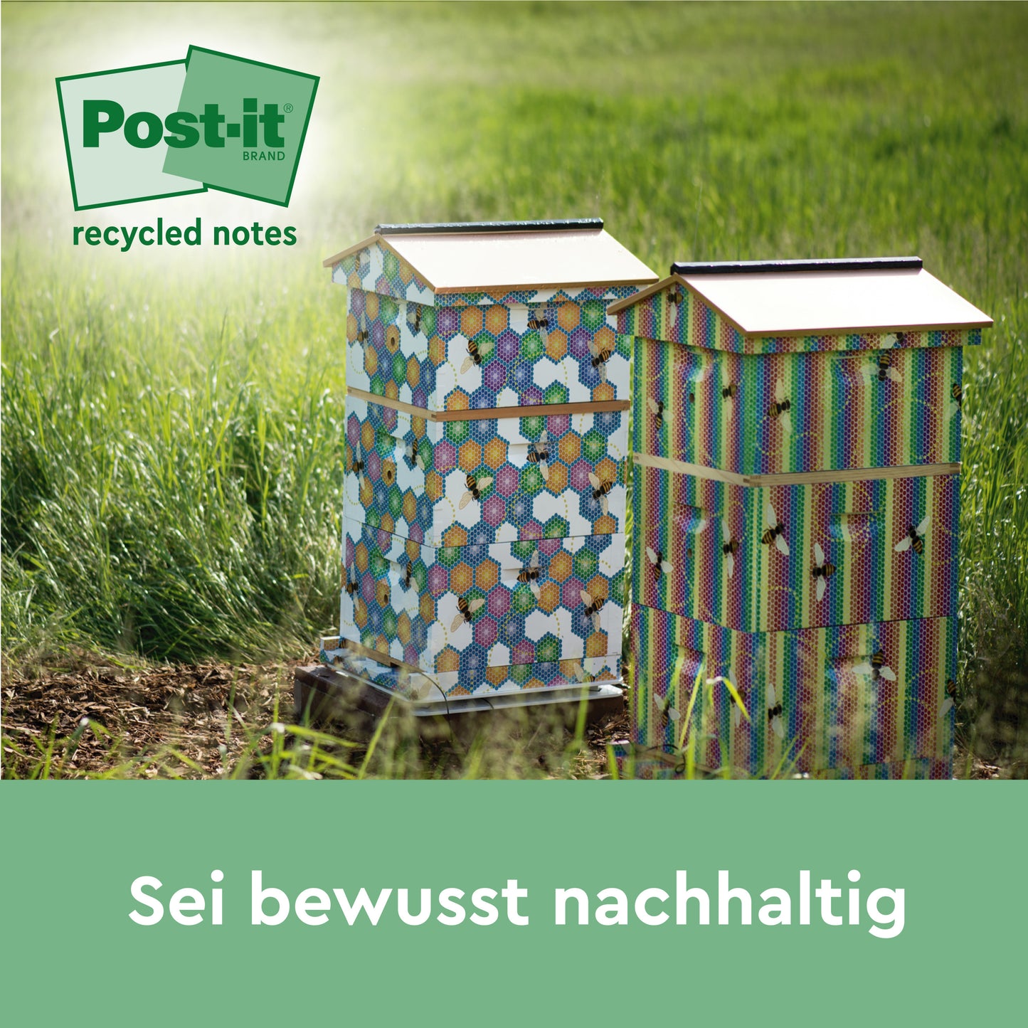 Two colorful beehives with hexagonal patterns stand in a meadow in the sunlight. In the corner appears the logo of Post-it® Super Sticky 100% Recycled Notes by 3M Deutschland GmbH. The text below reads: "Be consciously sustainable.