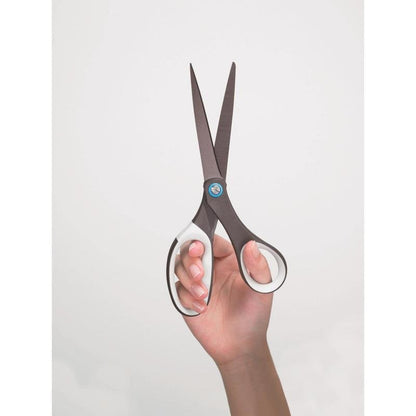 A hand holds an open pair of Scotch™ titanium scissors, 20 cm from 3M Deutschland GmbH, against a simple light background.