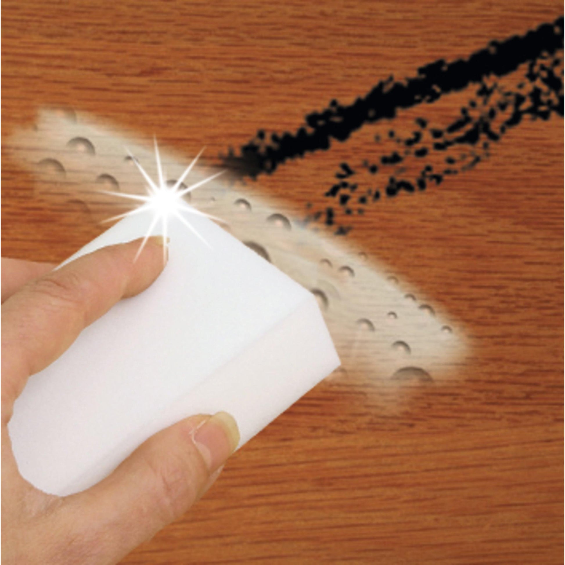 Eine Hand benutzt das Scotch-Brite® Magic Pad von 3M Deutschland GmbH, um schwarze Flecken und Wassertropfen von einer Holzoberfläche zu entfernen und eine saubere, glänzende Fläche zu erhalten.