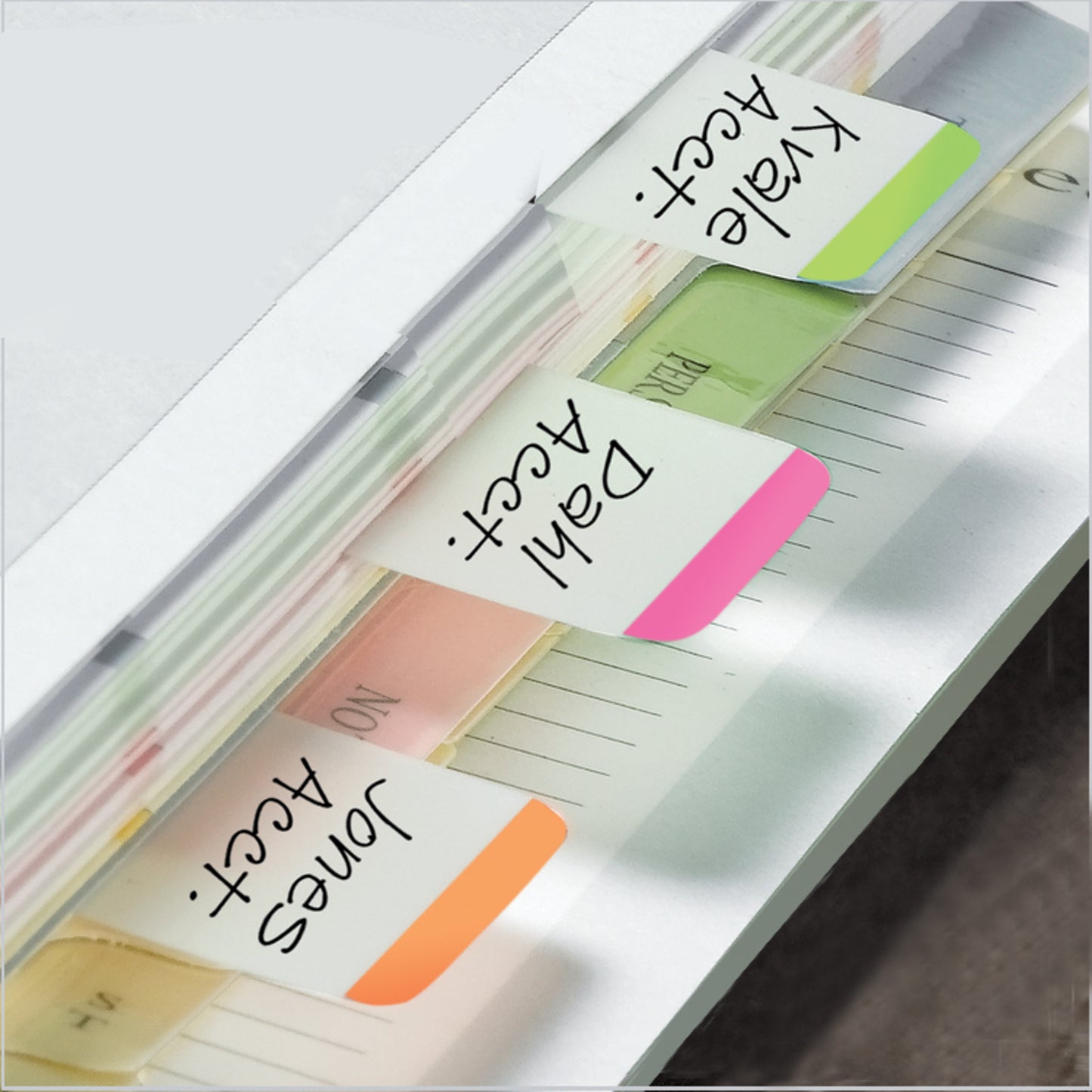 A close-up of a file folder organized with Post-it® Index Strong Filing Tabs from 3M Deutschland GmbH. Colored tabs in orange ("Jones Acct."), pink ("Dahl Acct."), and green ("Kale Acct.") mark different document sections.