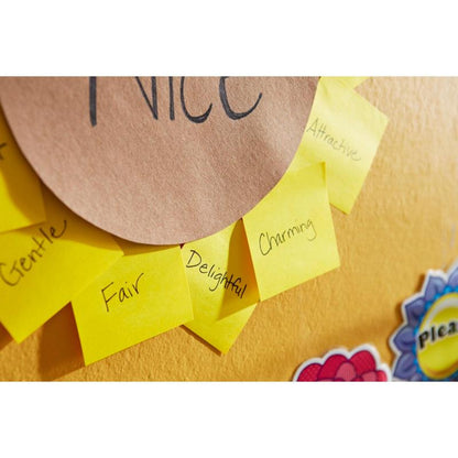 Post-it® Recycling Notes (38 mm x 51 mm, 100 sheets/block, 100% PEFC) from 3M Deutschland GmbH, labeled with positive adjectives such as "gentle," "fair," and "charming," are arranged in a circle on a yellow wall around brown paper with the word "nice."