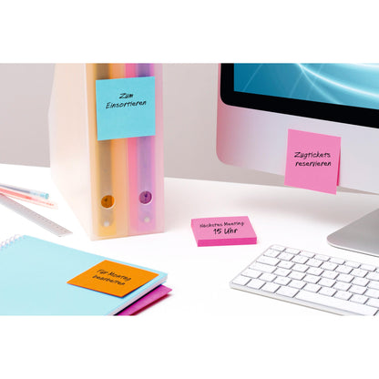 Ein aufgeräumter Schreibtisch mit zwei Ringbüchern, einem Monitor, einer Tastatur, einem Lineal, einem Notizbuch und bunten Post-it® Super Sticky Notes (76 mm x 127 mm, 90 Blatt/Block, 100% PEFC) von 3M Deutschland GmbH mit handschriftlichen deutschen Erinnerungshinweisen.