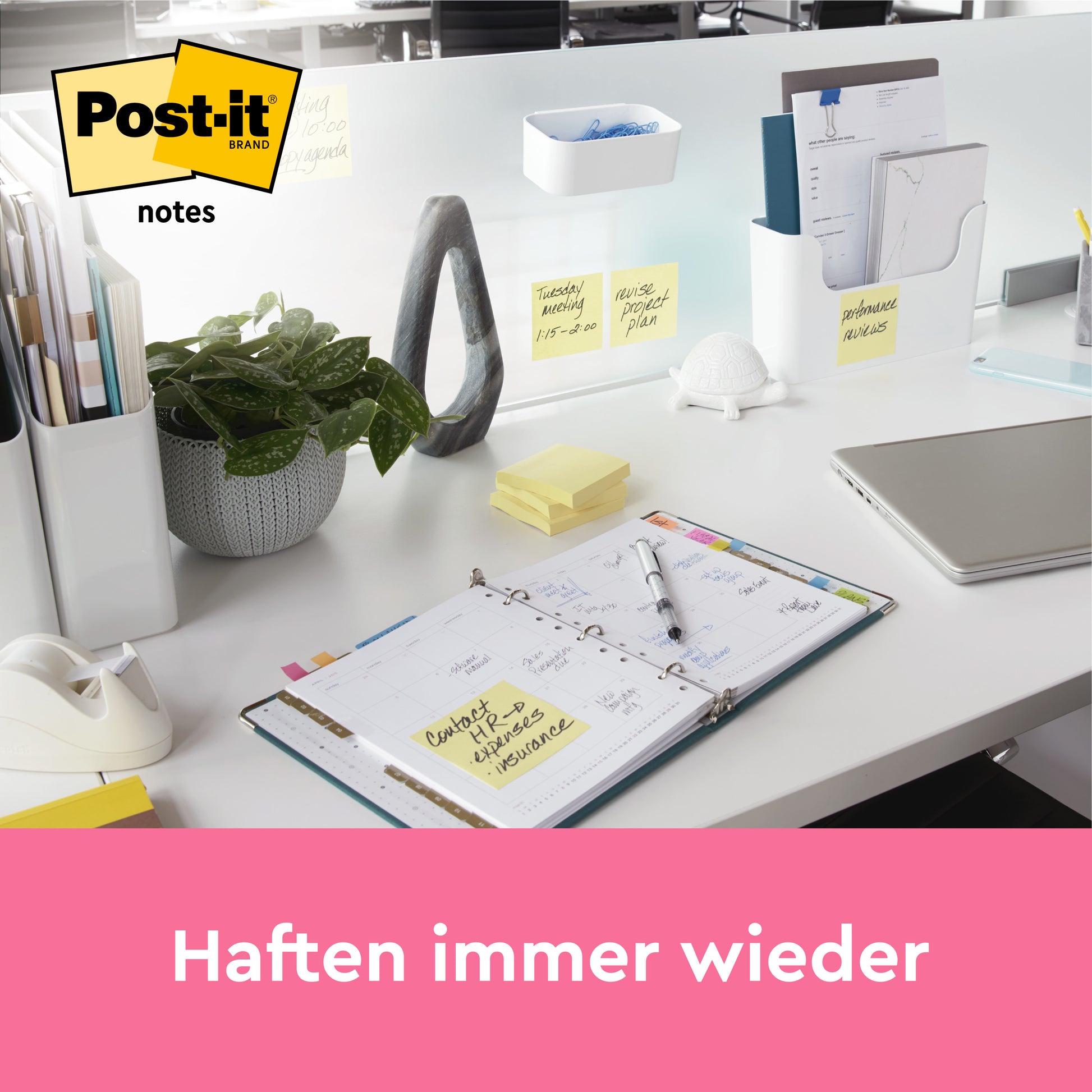 Auf einem aufgeräumten Schreibtisch liegen ein offener Planer, Schreibwaren, ein Laptop, eine Pflanze und mehrere Post-it® Notes Gelb (38x51 mm, 100 Blatt/Block, 3 Blöcke/Packung) der 3M Deutschland GmbH. Darunter steht auf einem rosa Banner "Haften immer wieder".