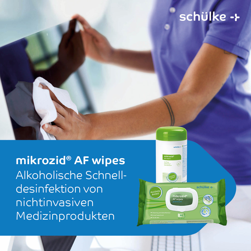 A person disinfects a laptop with Schülke mikrozid® AF wipes disinfectant wipes. The image shows the disinfectant wipes for medical products from Schülke & Mayr GmbH and highlights the rapid alcoholic disinfection of non-invasive medical products. The distinctive brand information is visible on both a container and a pack of wipes.